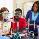 Students gather around a science experiment in a science classroom lab